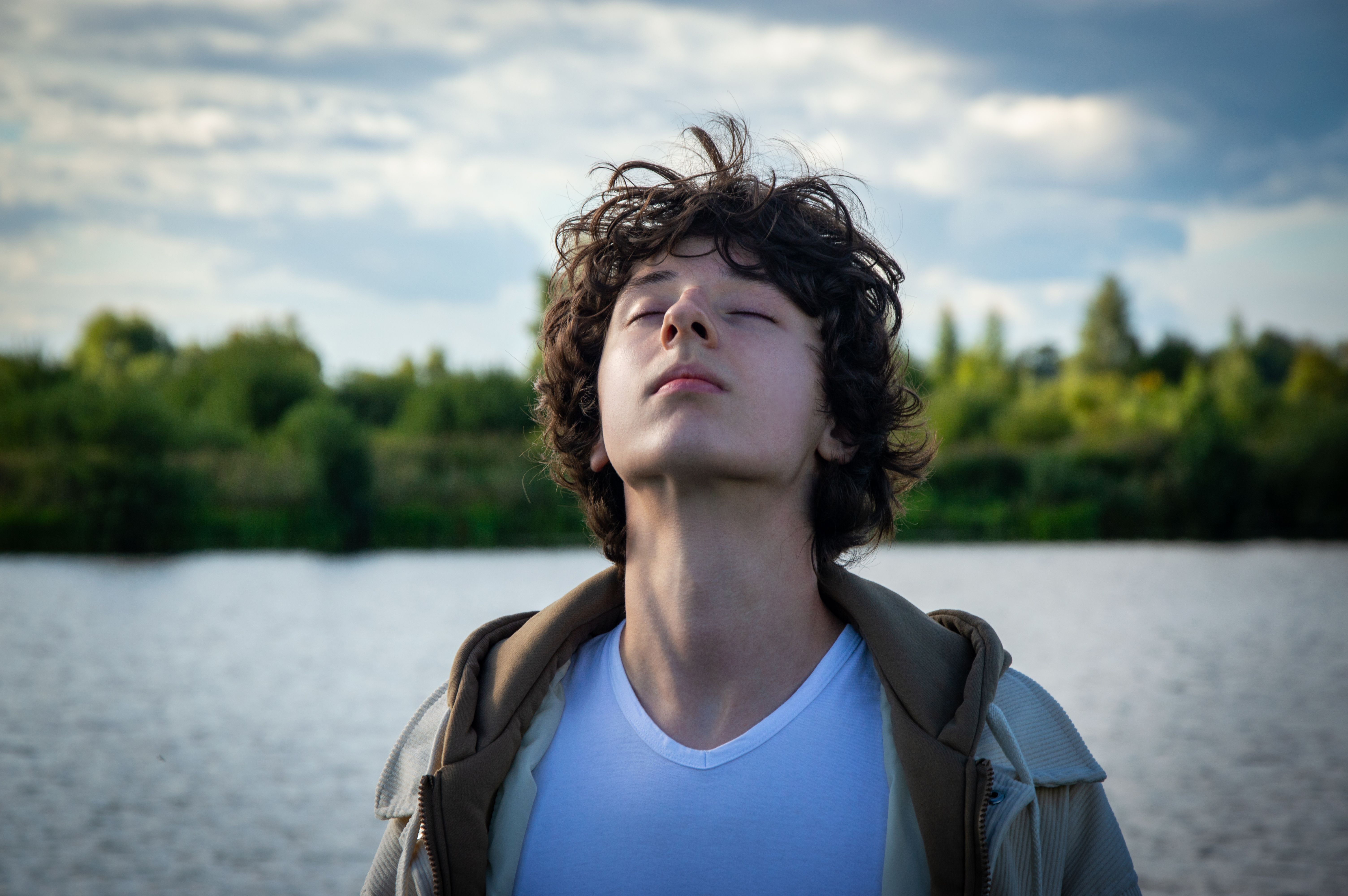 Joven respirando con los ojos cerrados junto al agua — la pausa de tres segundos, La Pausa #9